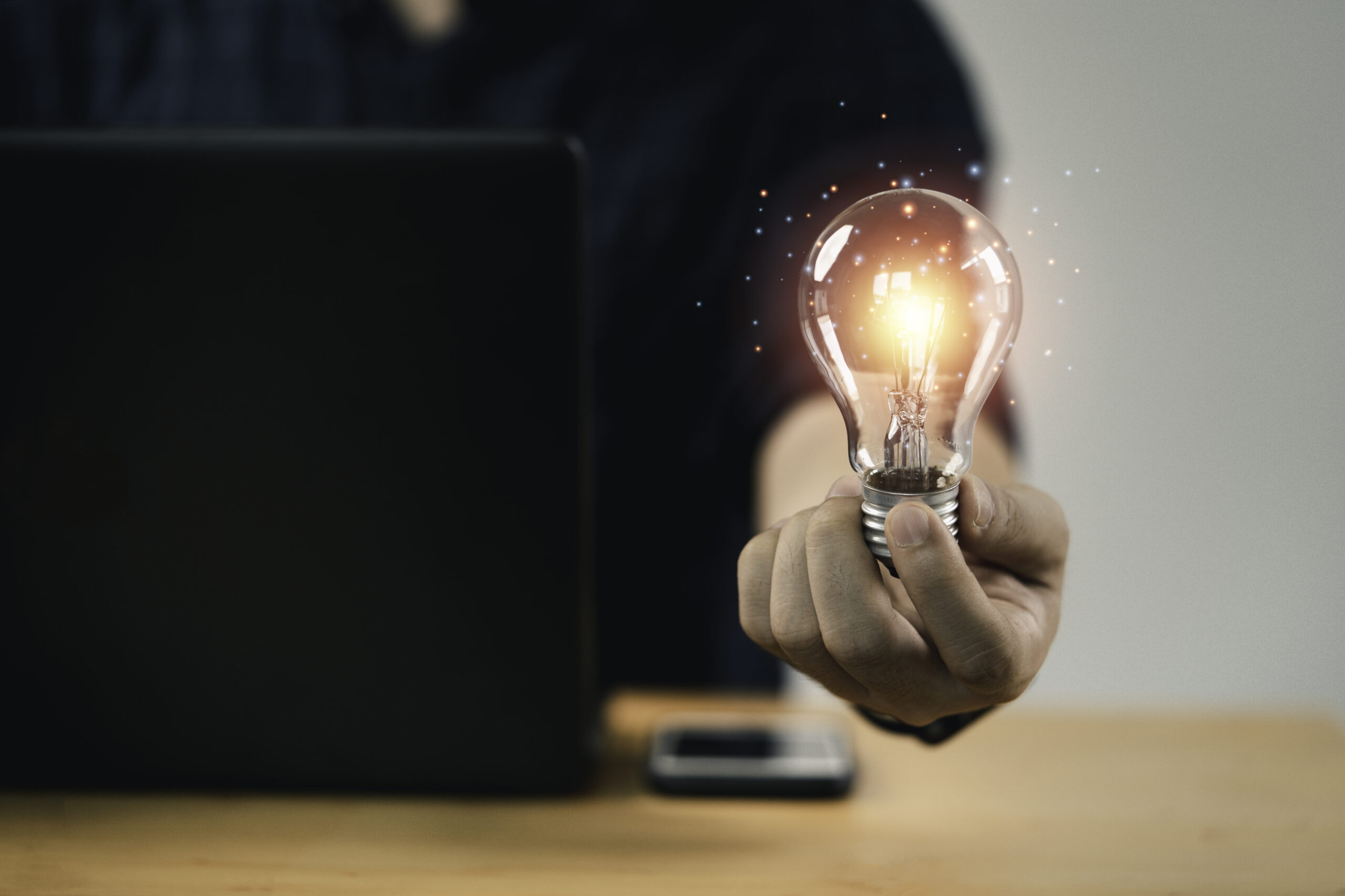 Businessman hand holding lightbulb with glowing light to creativ intellectual property advice for start up companies